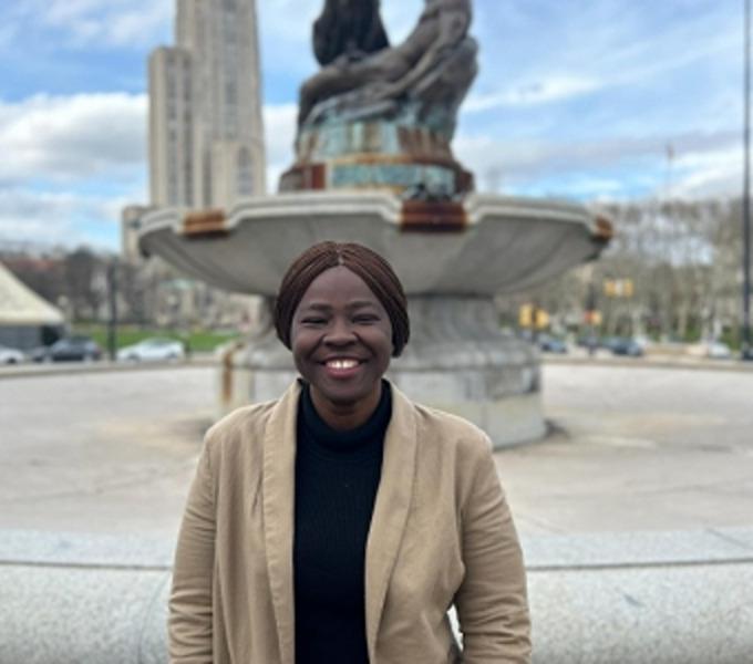 Gloria Jasmine Akoba standing in front of a sculpture fountain
