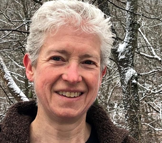 Jackie Smith standing in front of snow-covered trees