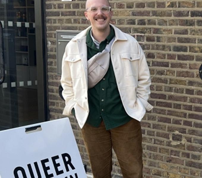 Joshua Warren standing next to a sidewalk sign